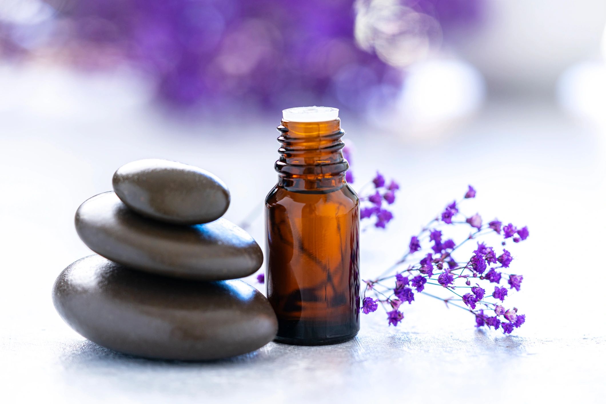 Essential oil bottle with stones and copy space