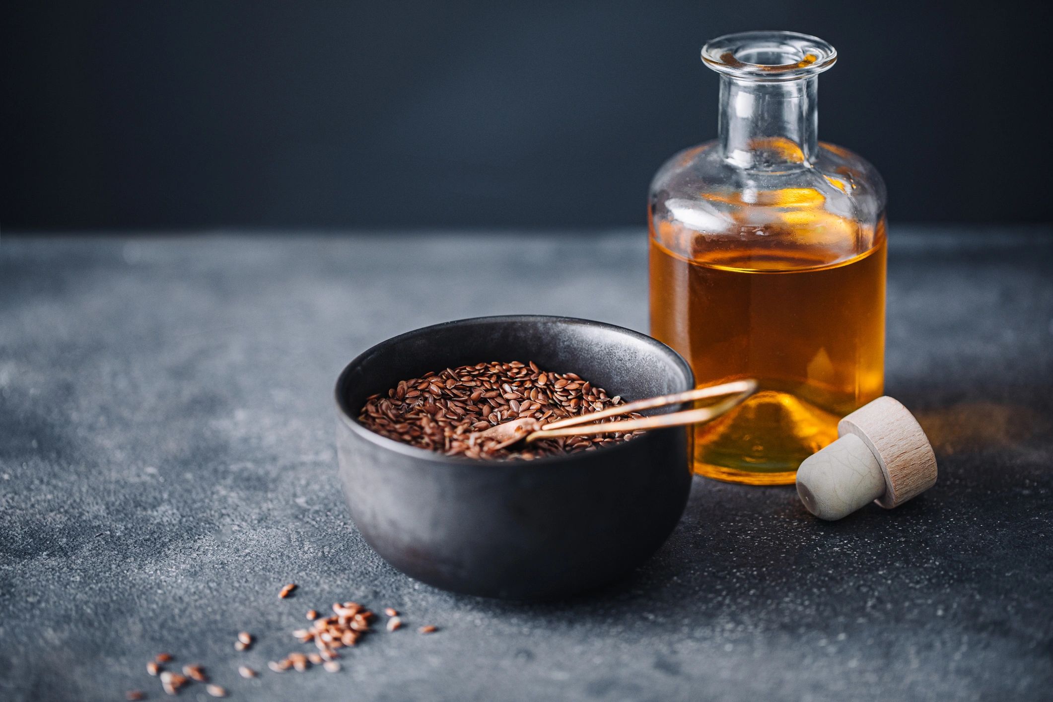 Glass bottle and seeds arranged as a natural wellness still life